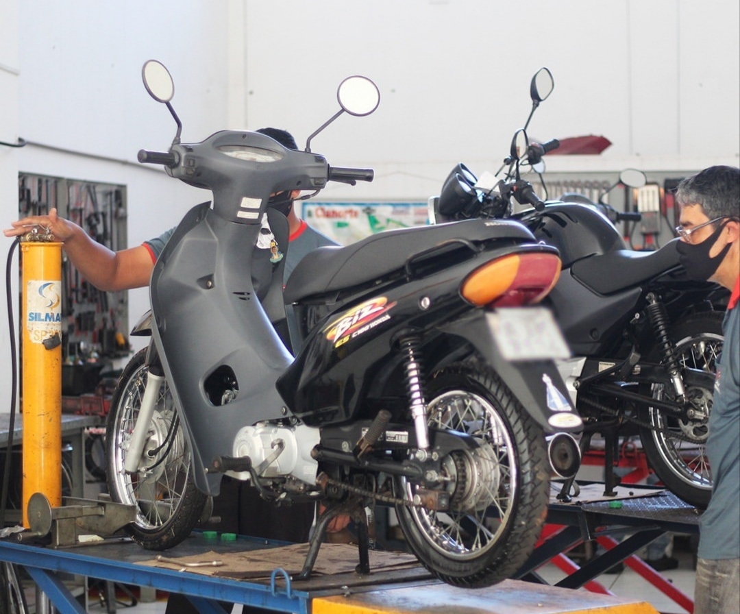 Mecânicos da Rui Motos atendendo motocicletas sobre a plataforma elevatória